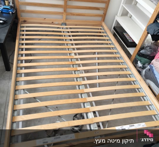 מיטה מעץ עם מסגרת מתכת בחדר שינה